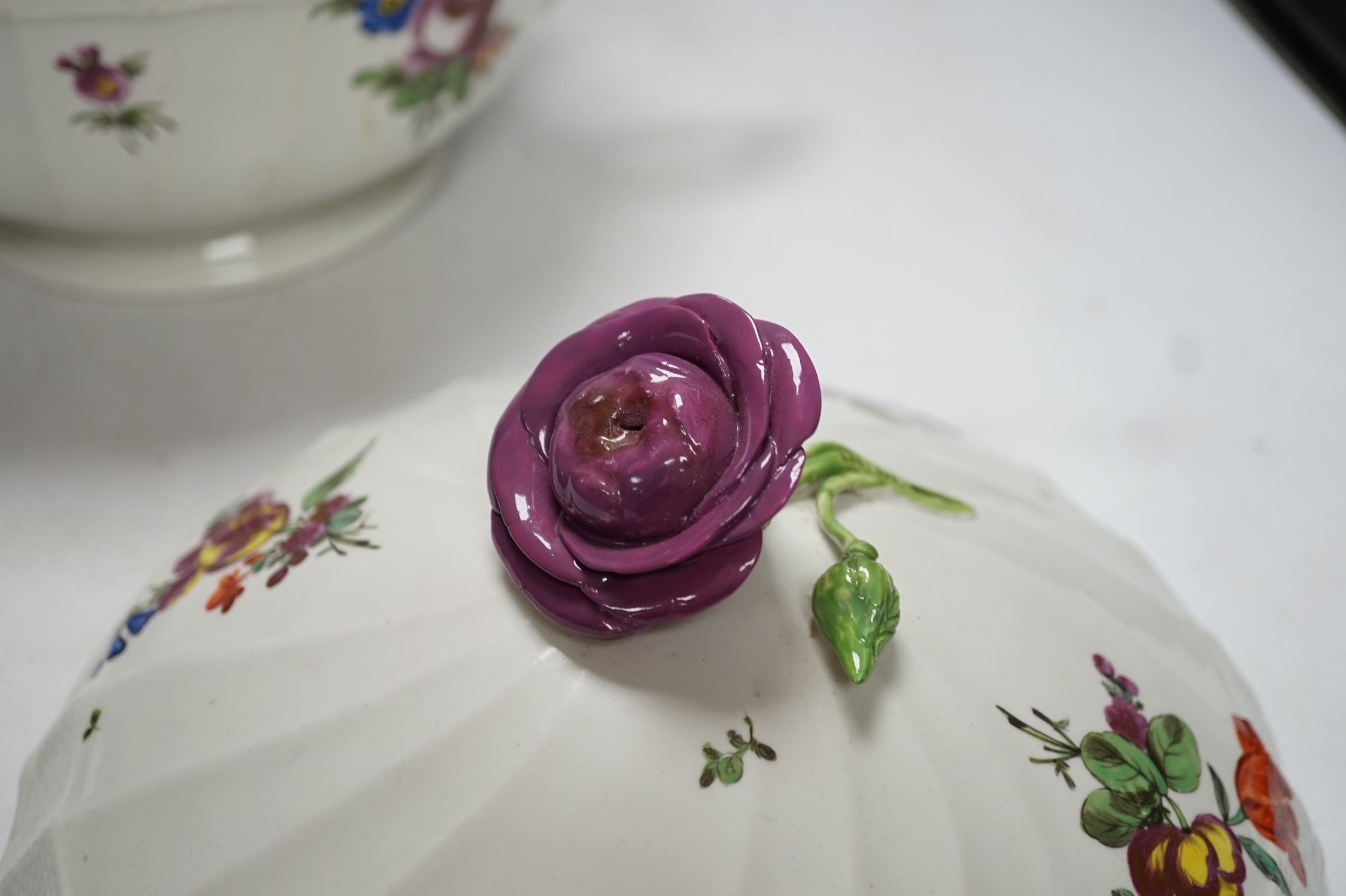 An 18th century Vienna tureen and cover, later outside decorated, with twin handles and floral knop, 38cm wide